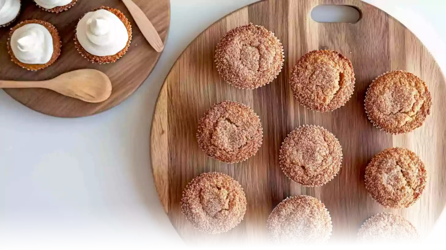 Freshly baked cinnamon sugar French toast muffins on a wooden serving board.