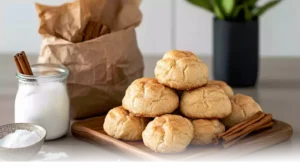 Golden Churro Cheesecake Cookies coated in cinnamon sugar, served on a rustic wooden tray in a bright kitchen