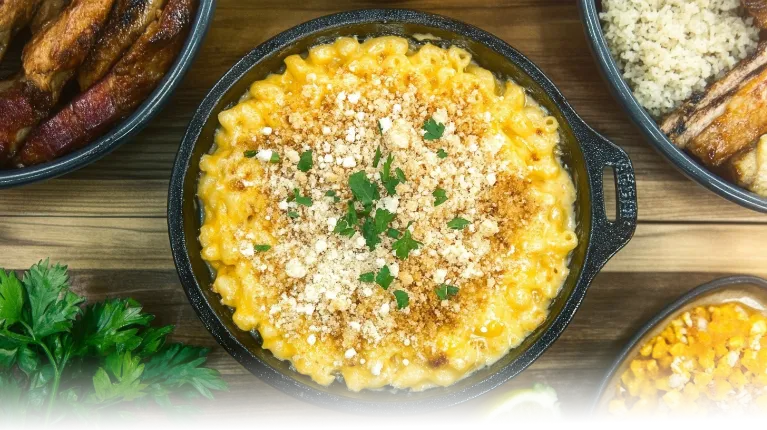 Golden smoked mac and cheese topped with parsley and panko breadcrumbs, served in a cast iron skillet.