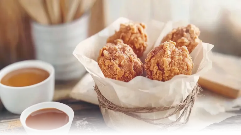 Playful Fried Chicken Ice Cream served in a basket with caramel and chocolate dipping sauces.