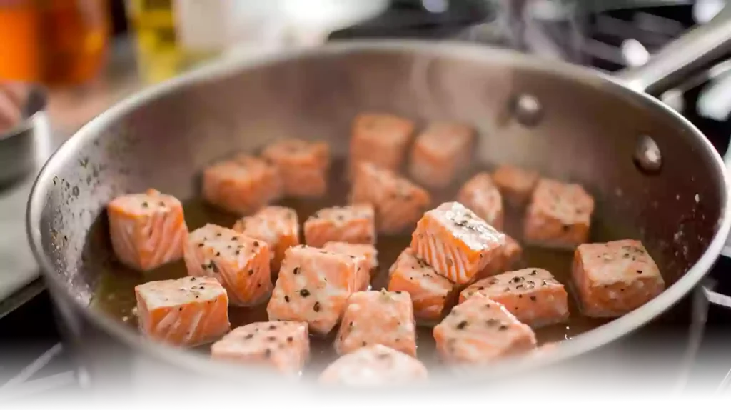 Fresh salmon cubes and ingredients for Hot Honey Salmon Bites laid out on a sleek kitchen counter in natural light.